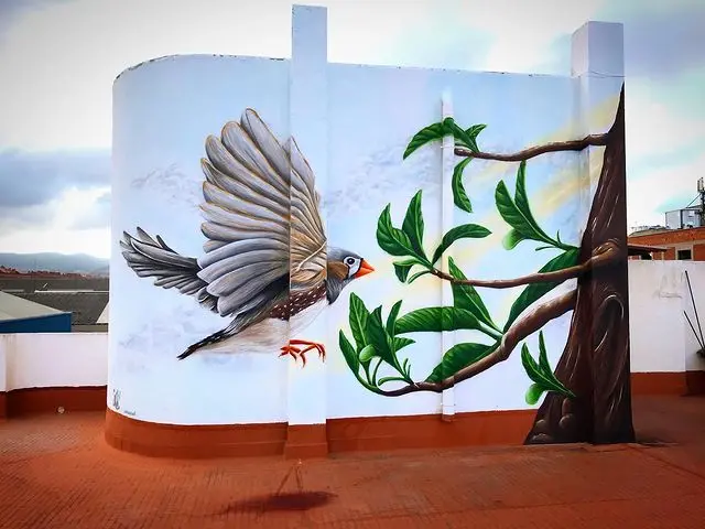 Decoración de terraza privada con mural de 4 metros de altura con un pájaro y un árbol, trabajo de MuralONAs