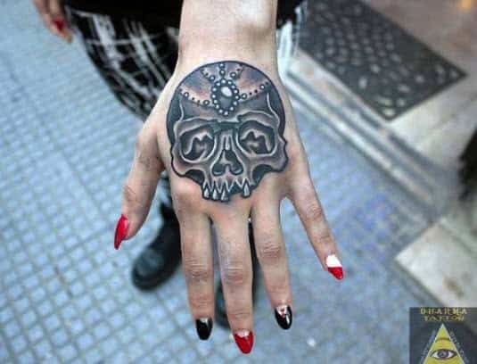 Tattoo en la mano con una calavera, trabajo de Dharma Tattoo