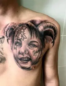 Tatuaje cara de una niña realista en el pectoral