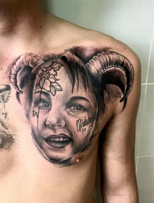 Tatuaje cara de una niña realista en el pectoral