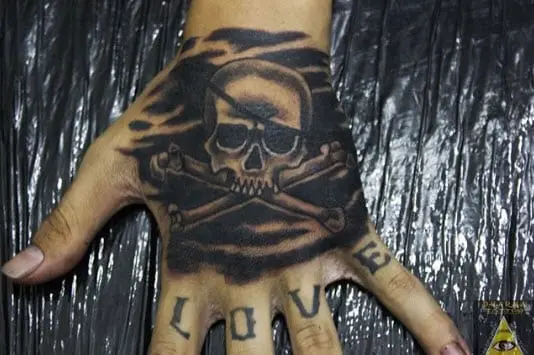 Tatuaje calavera pirata en la mano, trabajo de Dharma Tattoo
