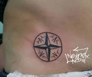 Tatuaje en el pubis (hombre) de una flor de los vientos