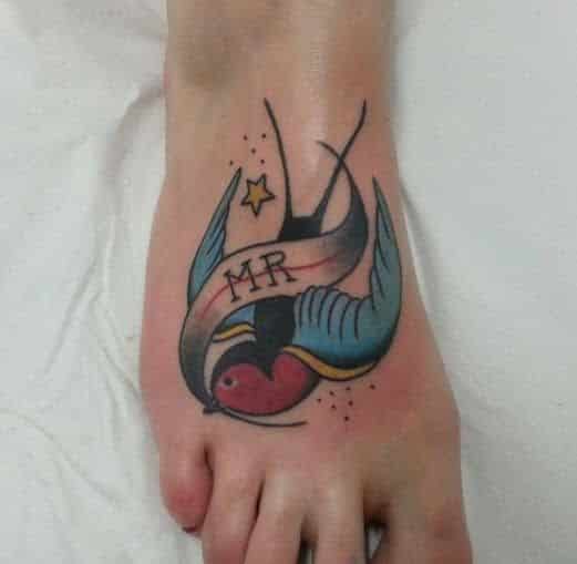 Tatuaje tradicional pie pájaro, trabajo de Nautilus Tattoo Gallery Vallekas