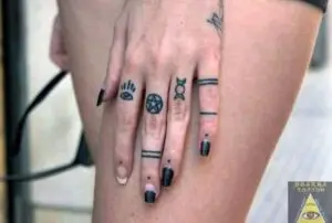 Tatuajes símbolos en los dedos de una mujer