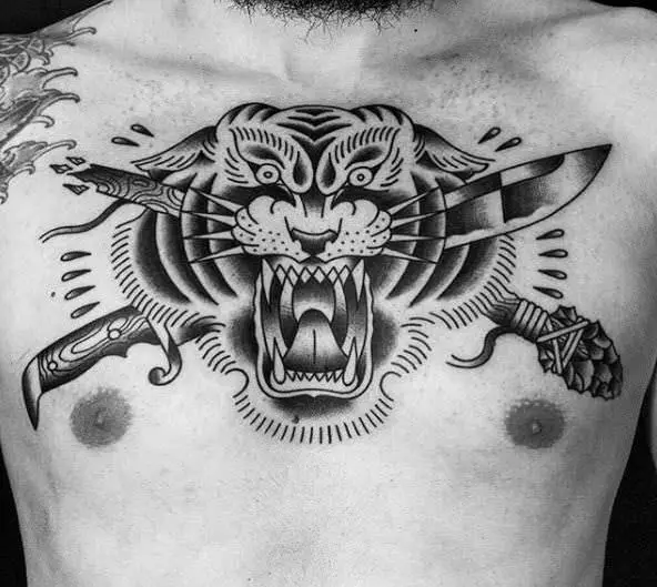 Tatuaje de cabeza de tigre con cuchillos cruzados, trabajo de Inkpulso Tattoo