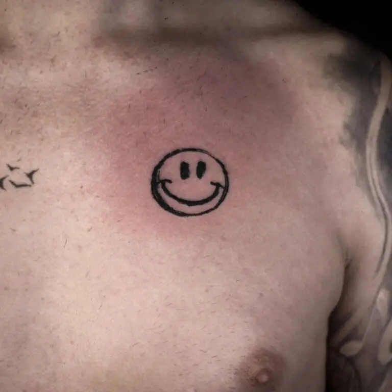 Cara sonriente en el pecho, trabajo de Vanir Tattoo