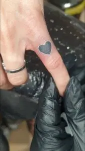 Corazón negro en el dedo