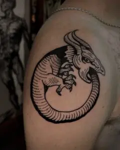 Dragón ouroboros en blackwork en el hombro