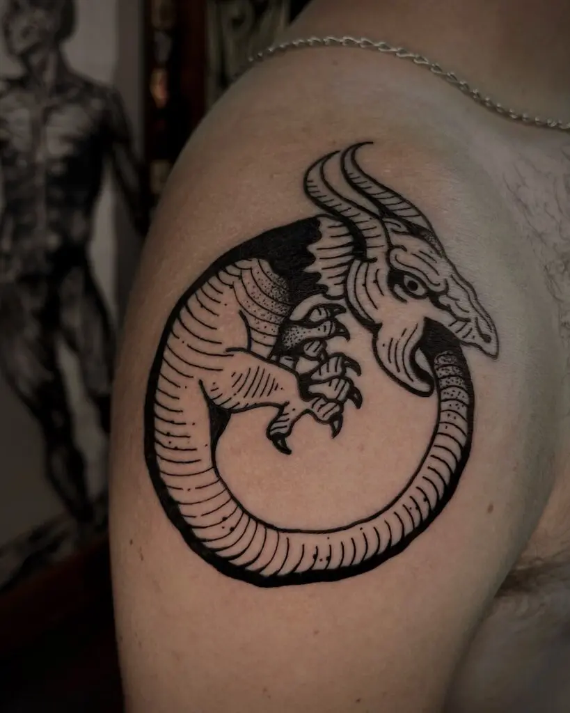 Dragón ouroboros en blackwork en el hombro