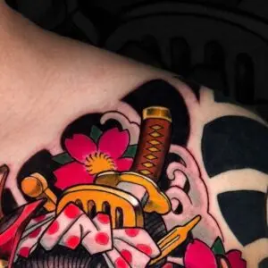 Tatuaje japonés con katana y flor de cerezo en el pecho