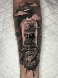 Tatuaje realista de alienígena en el antebrazo